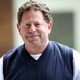 Kotick wears a sweater and a TV shirt as he half-smiles.